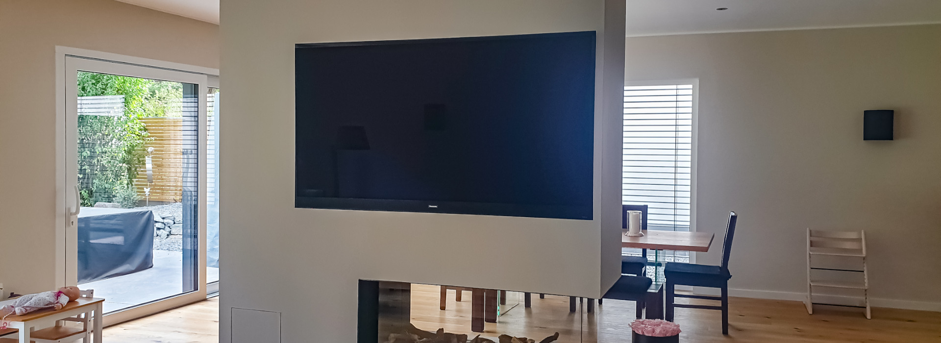 TV und Netzwerktechnik: Das Bild zeigt einen Fernseher, der flach in die Wand über einem Kaminofen eingelassen ist
